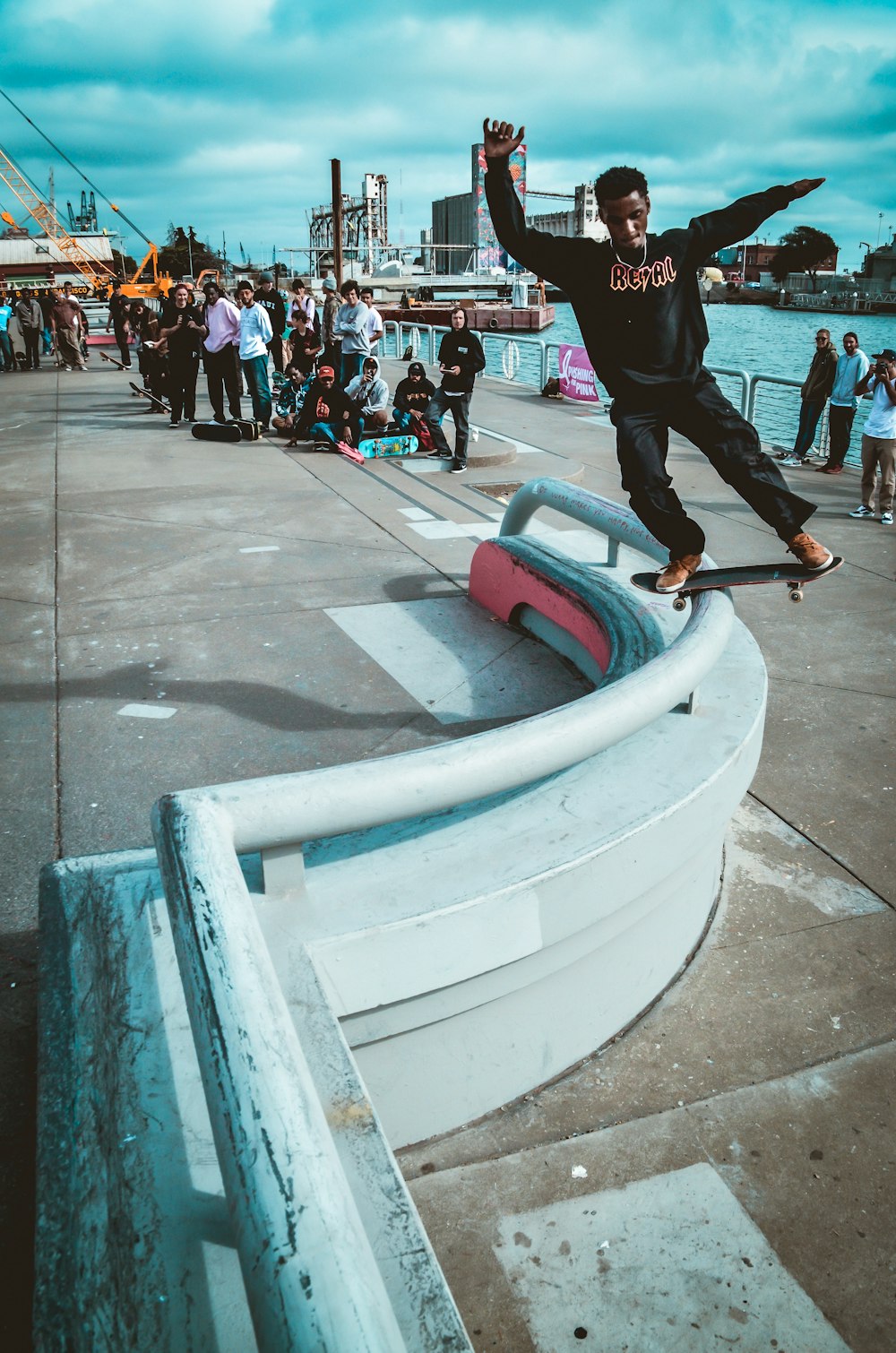 man wearing black sweater riding skateboard and balancing on teal metal  hand rail photo – Free Grey Image on Unsplash
