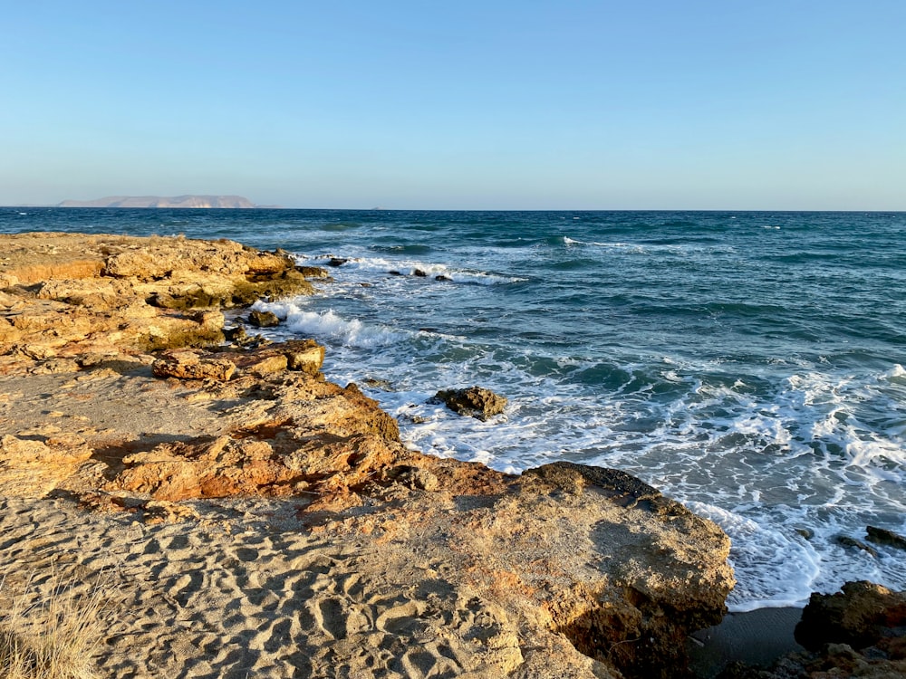 Spruzzi delle onde del mare sulle rocce durante il giorno
