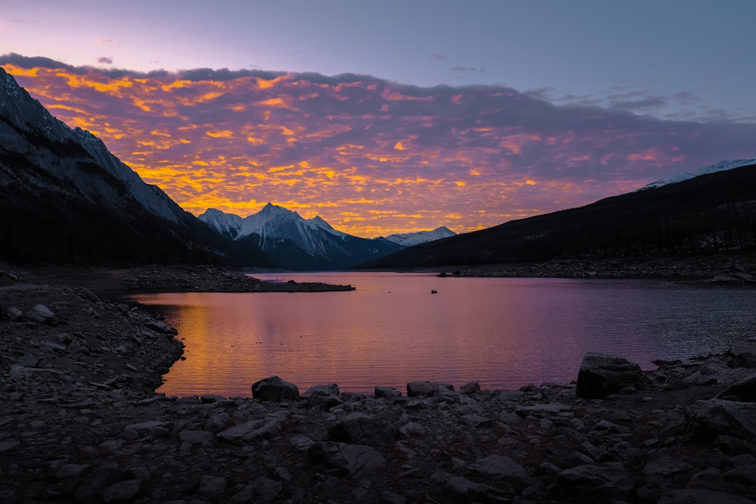 mountain near body of water at sunset