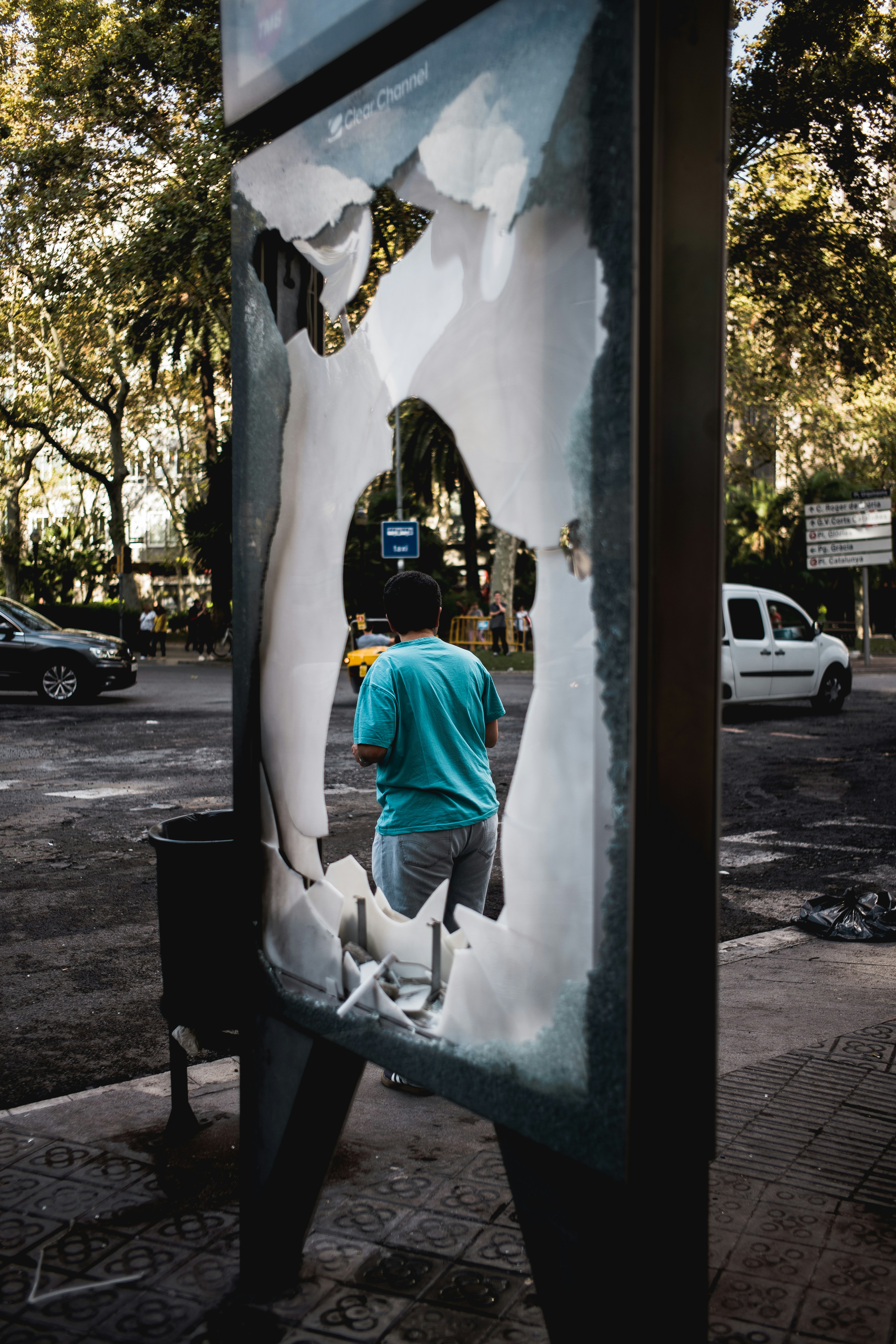 A man is standing in front of a broken sign - missing and damaged markers