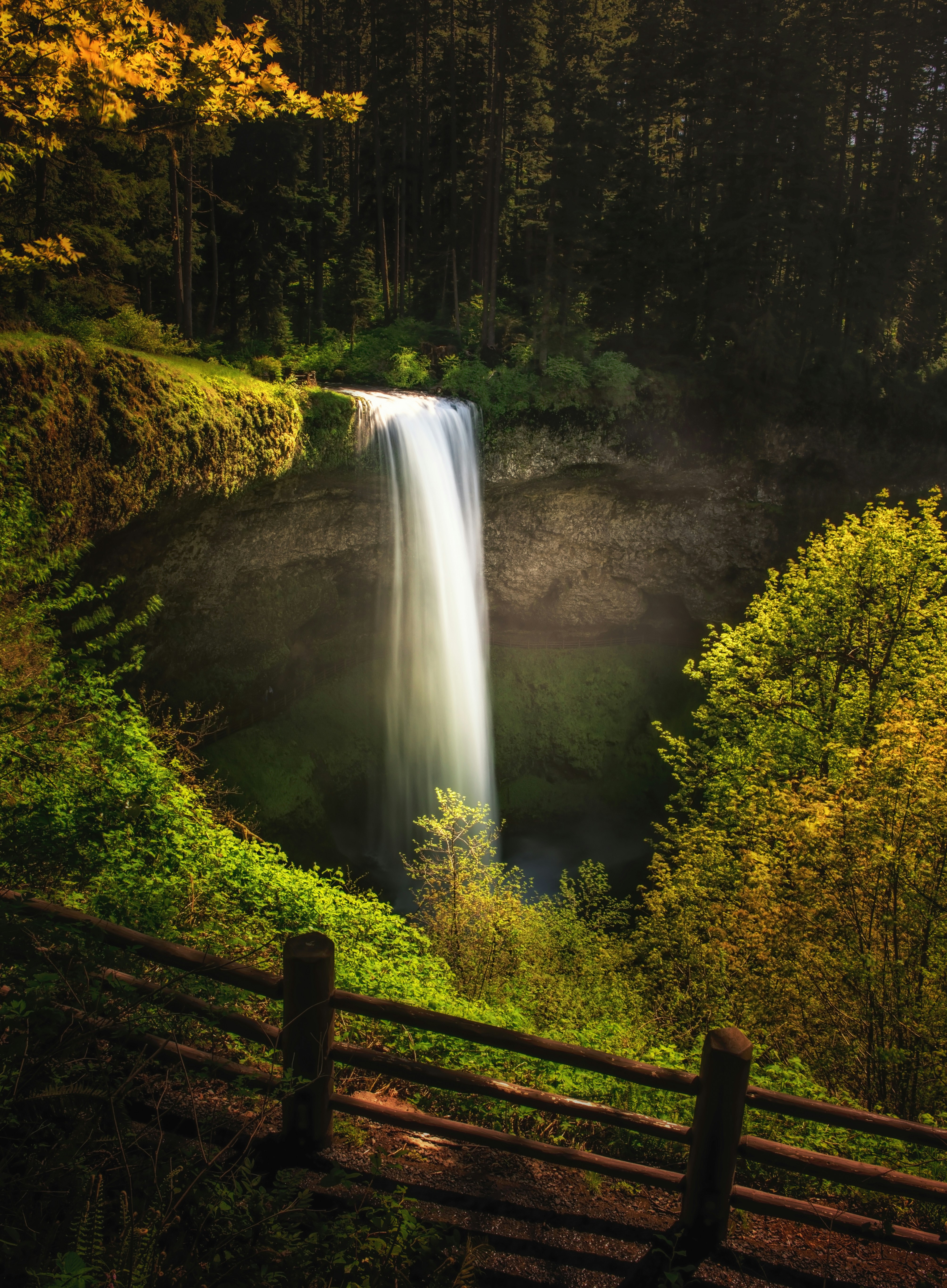 waterfalls with brown wooden fence