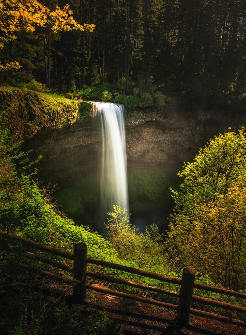 waterfalls with brown wooden fence