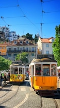 people inside yellow tram and others are standing near road during daytime