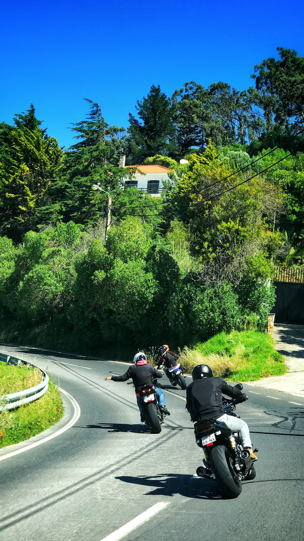 three bikers crossing on curve road