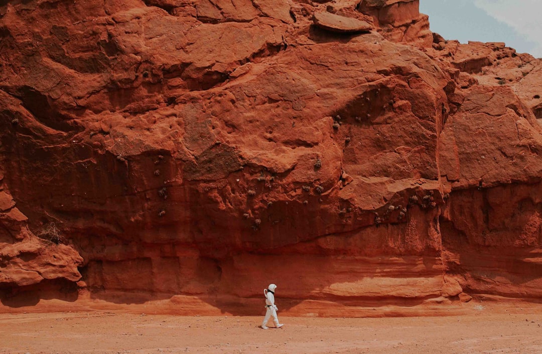 person walking near brown rock, mars