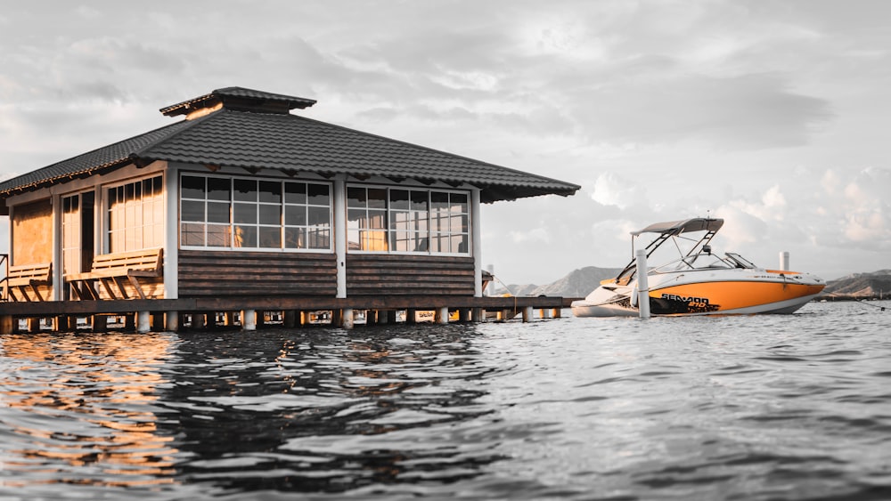 boat beside gray wooden floating house