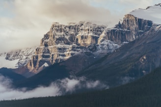 a mountain range covered in snow and clouds