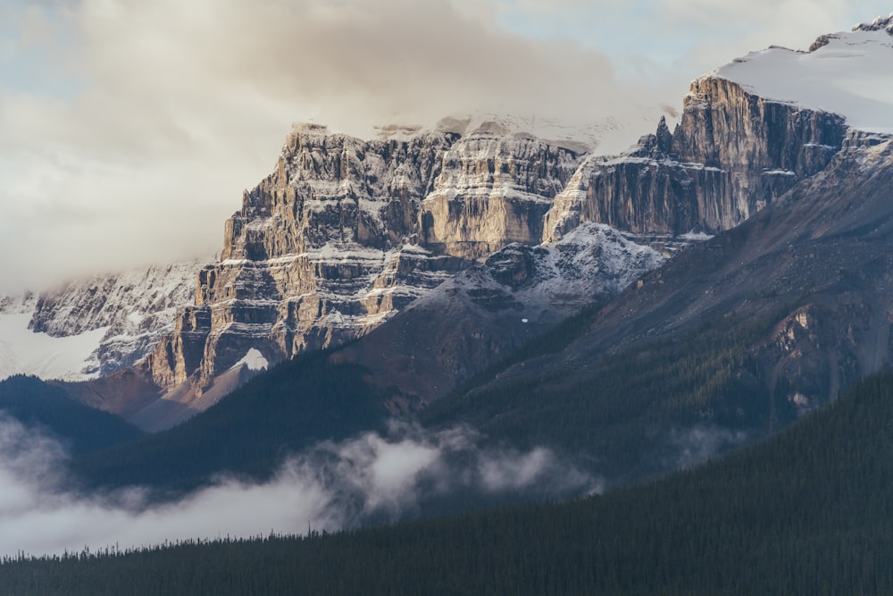 a mountain range covered in snow and clouds