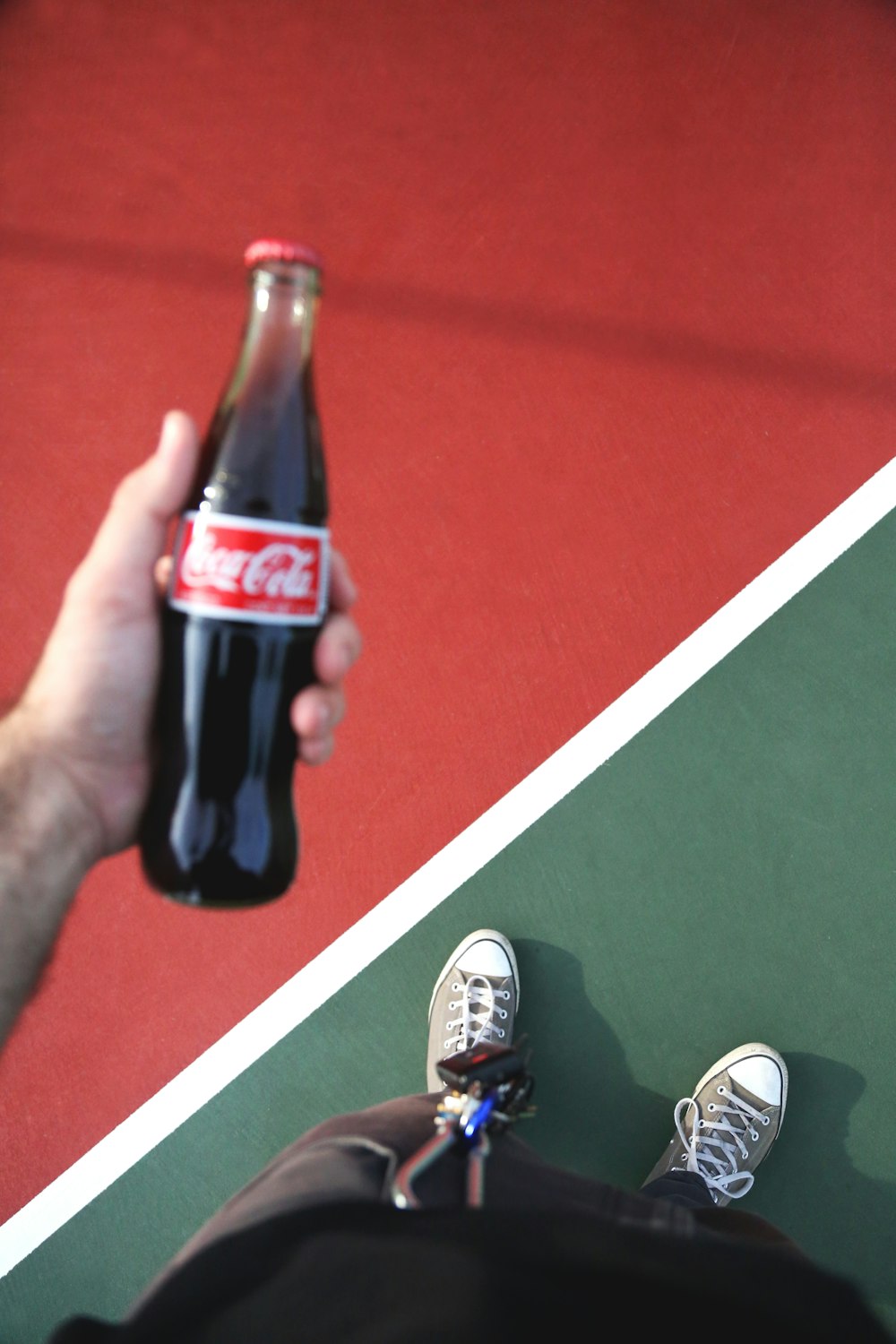 persona sosteniendo una botella de Coca-Cola