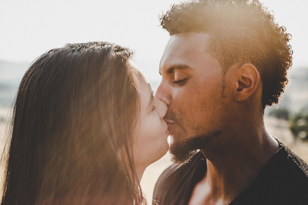 man kissing woman during daytime