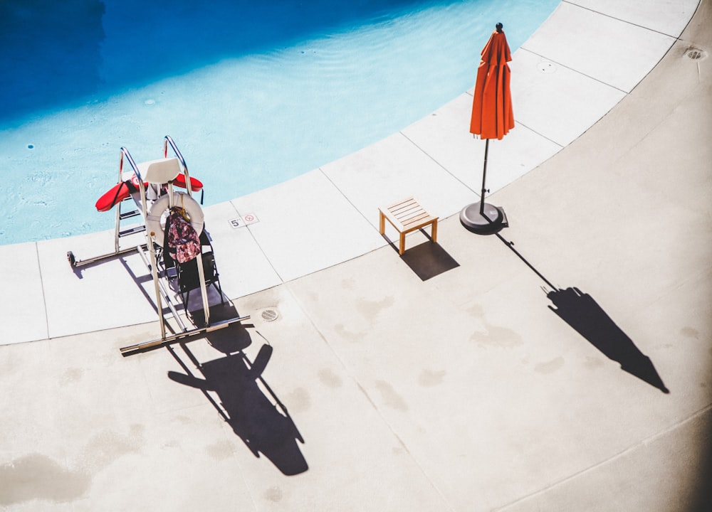 orange pool umbrella near blue swimming pool during daytime