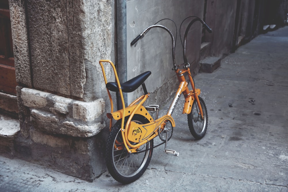 brown low-rider bike beside wall