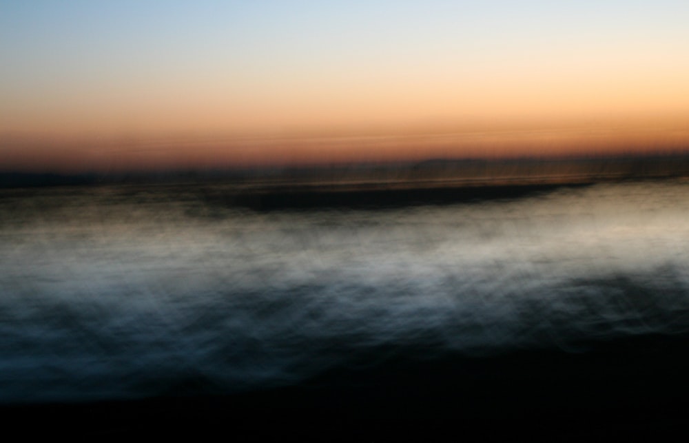 a blurry photo of a sunset over a body of water