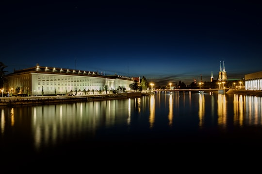 reflection of building lights on body of water at night in Cathedral of St. John the Baptist Poland