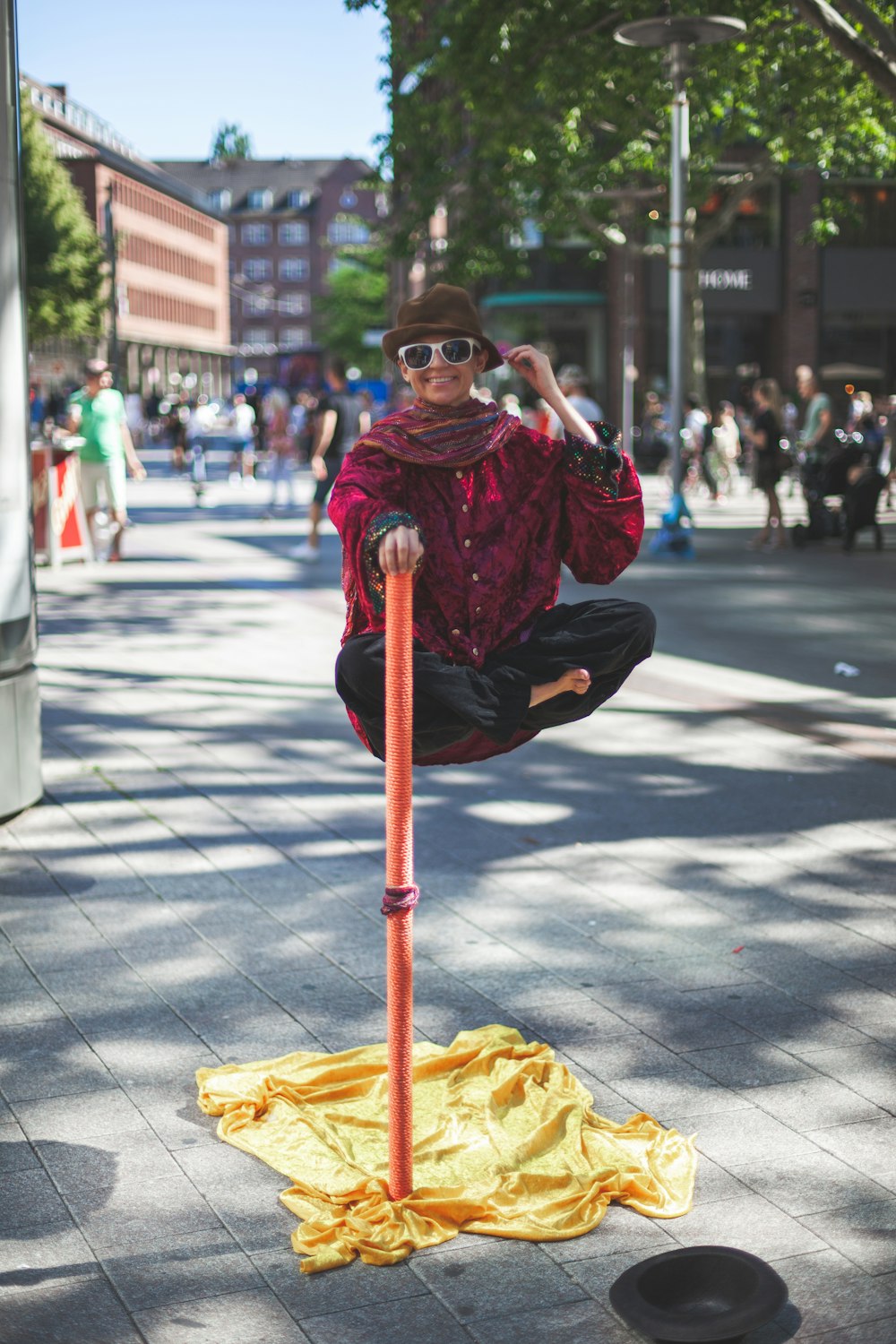 man floating holding on orange stick white people watching on the street