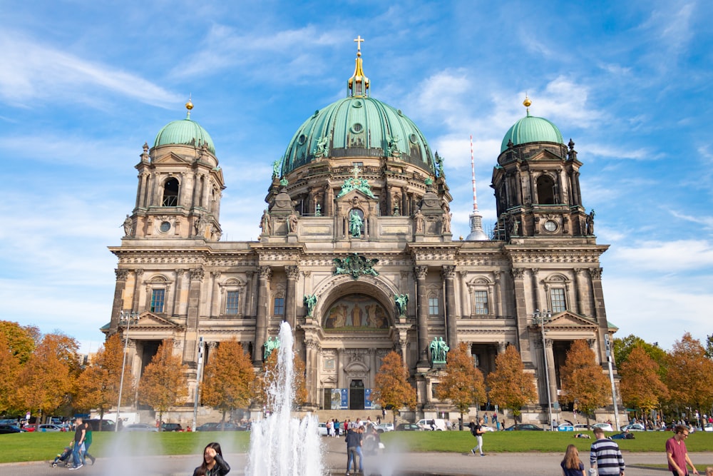 Wasserfontäne vor grauem Betonkuppelgebäude