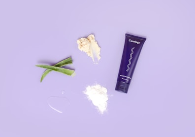 Flat lay of trulyfair's dark spot cream surrounded by fresh botanical ingredients.