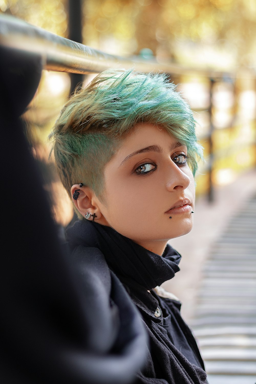 woman wearing black top leaning on metal railings