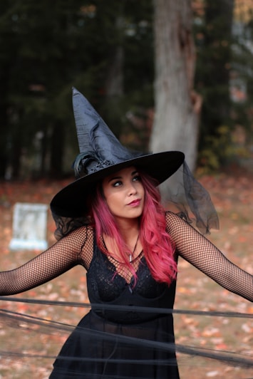 woman in black spaghetti strap dress and wearing witch hat