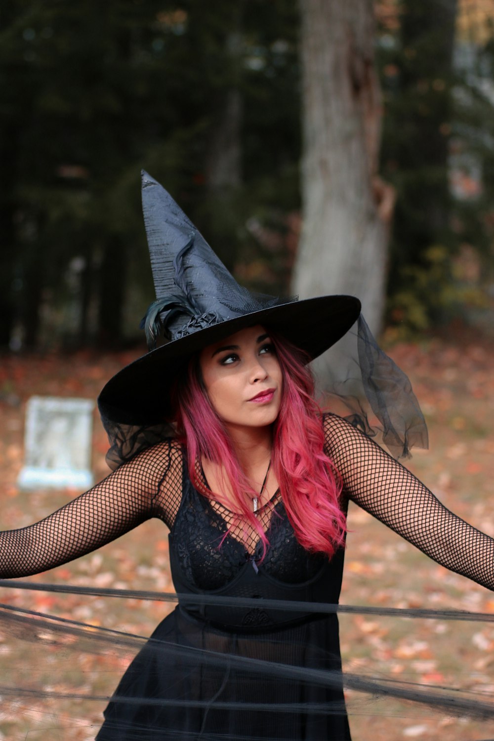 woman in black spaghetti strap dress and wearing witch hat