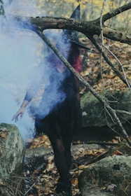 woman in witch costume standing beside rock