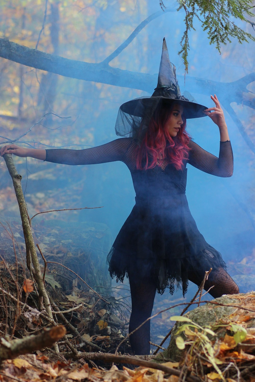 woman in black witch costume standing beside rock