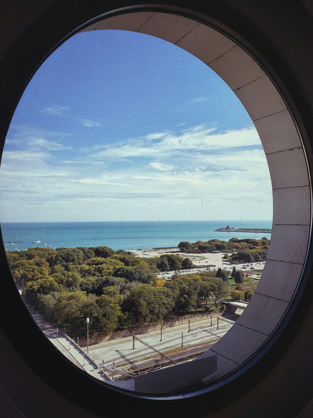 round window overlooking trees and ocean