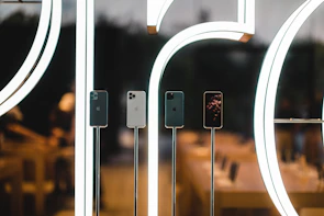 Display of the latest smartphones arranged neatly on a dark, stylish store counter.