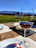 A rustic wooden table set with traditional Tuscan dishes and a glass of red wine overlooking rolling Chianti hills at sunset.