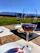 A rustic wooden table set with traditional Tuscan dishes and a glass of red wine overlooking rolling Chianti hills at sunset.