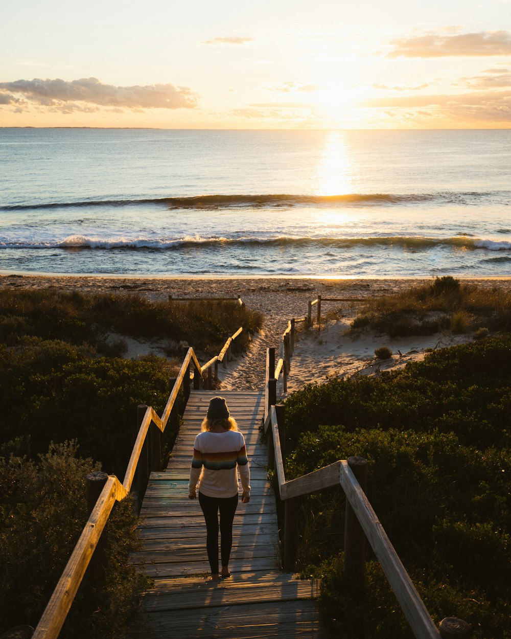 woman walking on dock at beach