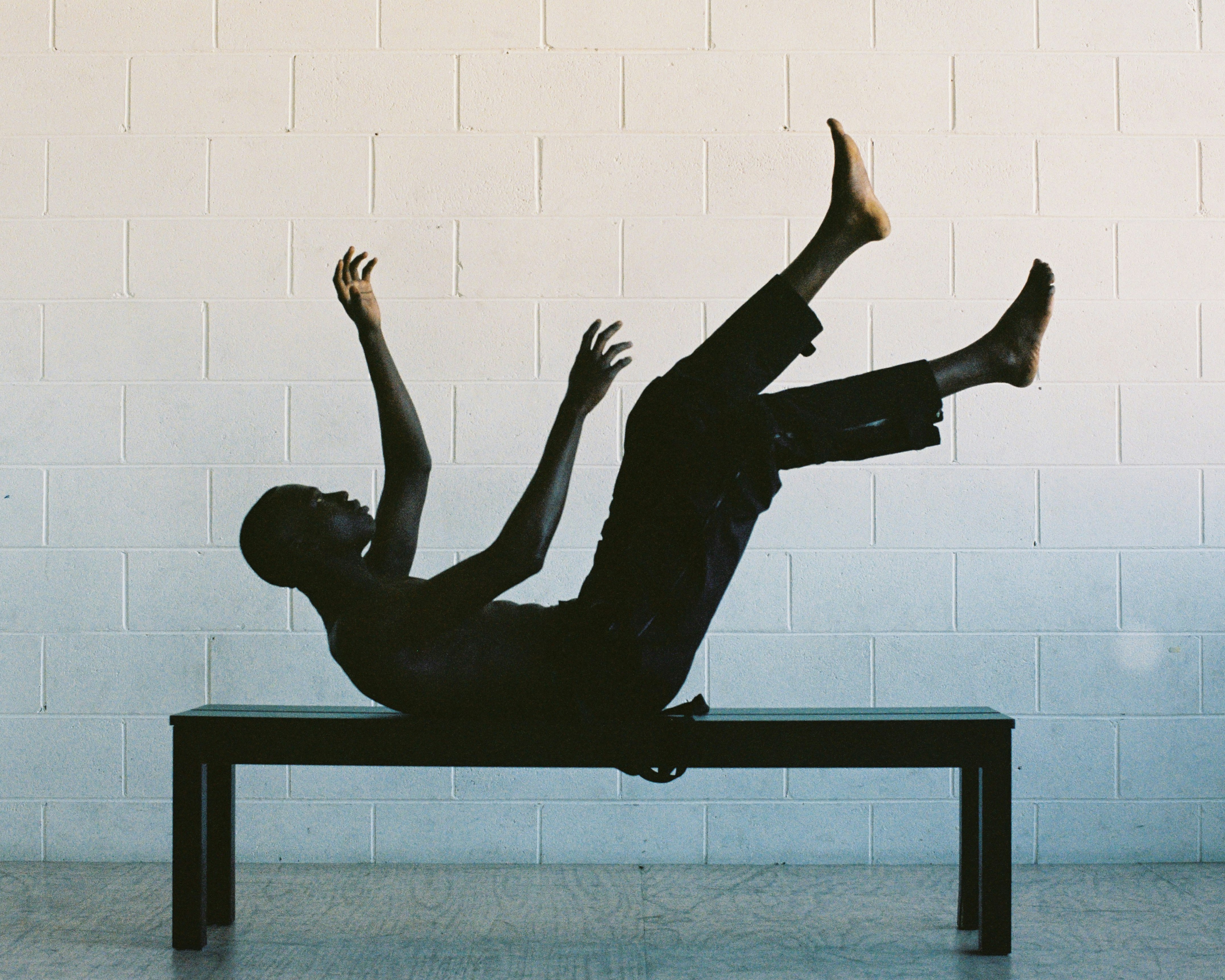 man lying on black wooden table