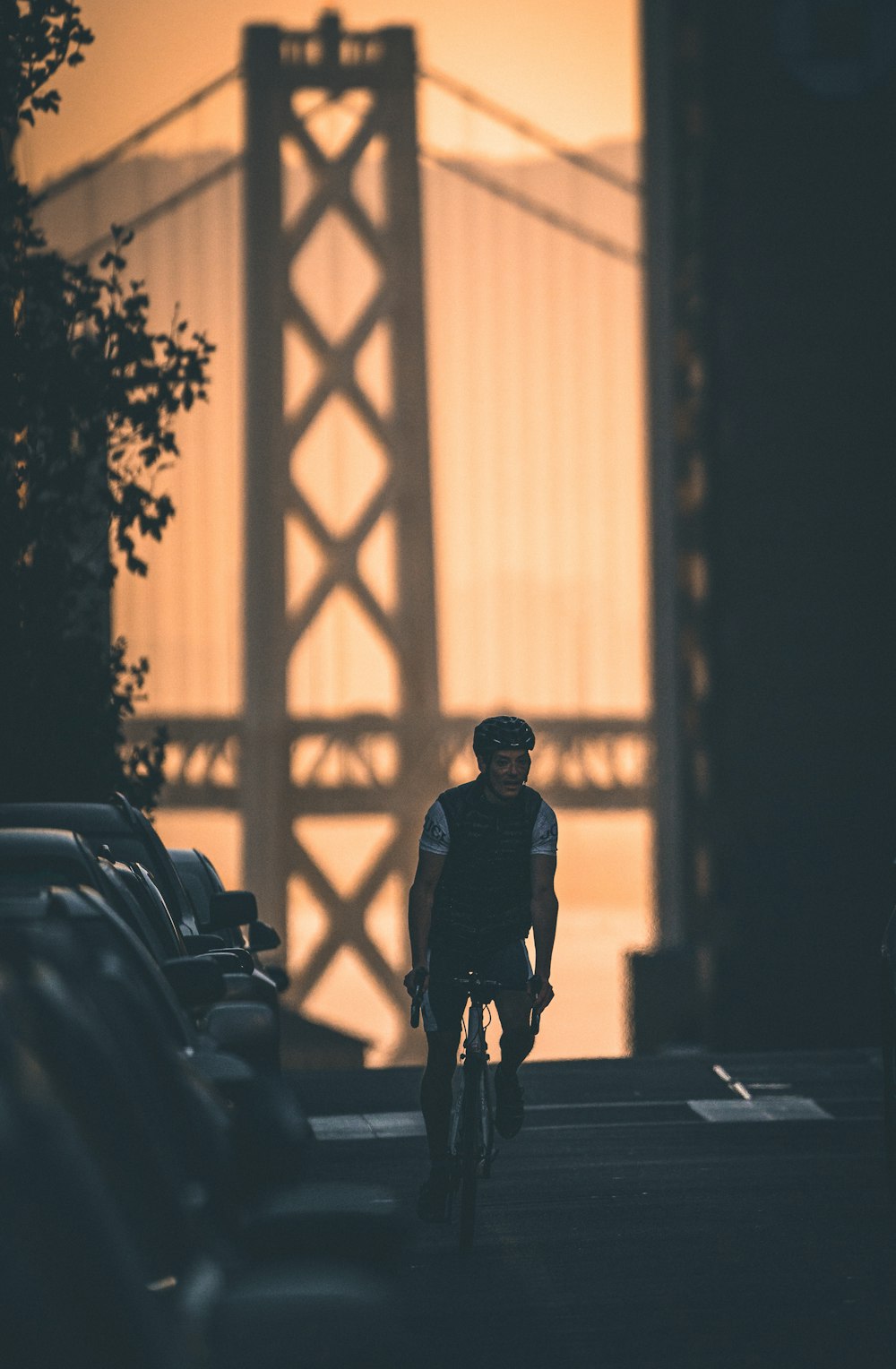 man riding bike beside parked cars during day