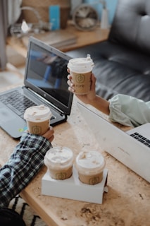 An outdoor meeting with a laptop and coffee cups.