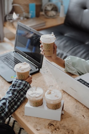 Researchers exchanging ideas during a coffee break against a backdrop of university logos.