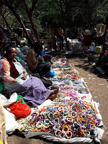 A lively crowd browsing through quirky vintage jewelry at an outdoor market.
