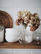 flowers in vase beside dishes