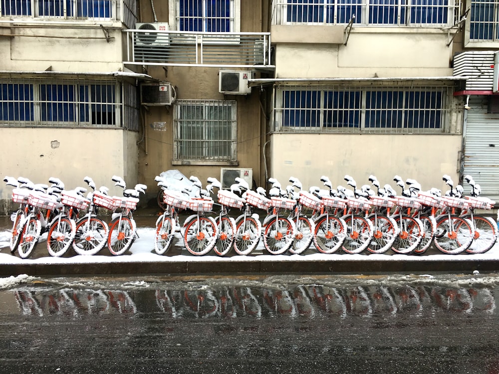 line of parked bikes in front of building during day