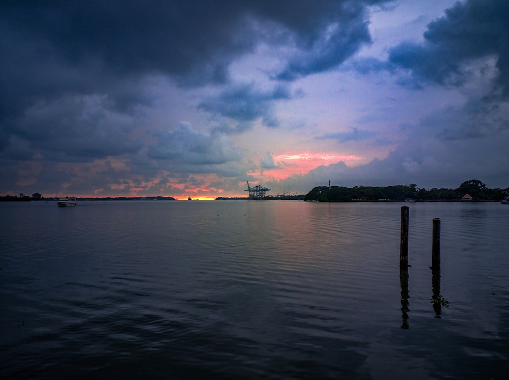 calm body of water under cloudy sky