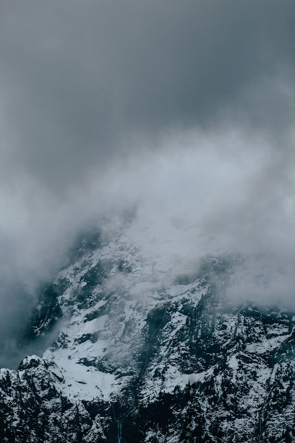 snow covered mountain under cloudy sky