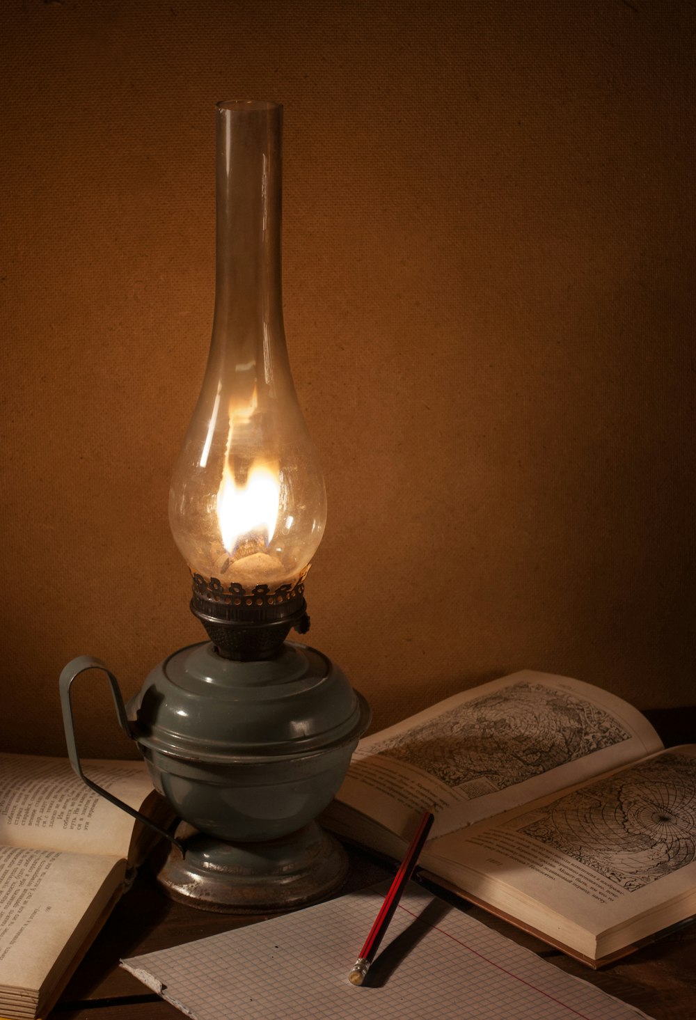 gray oil lamp beside book