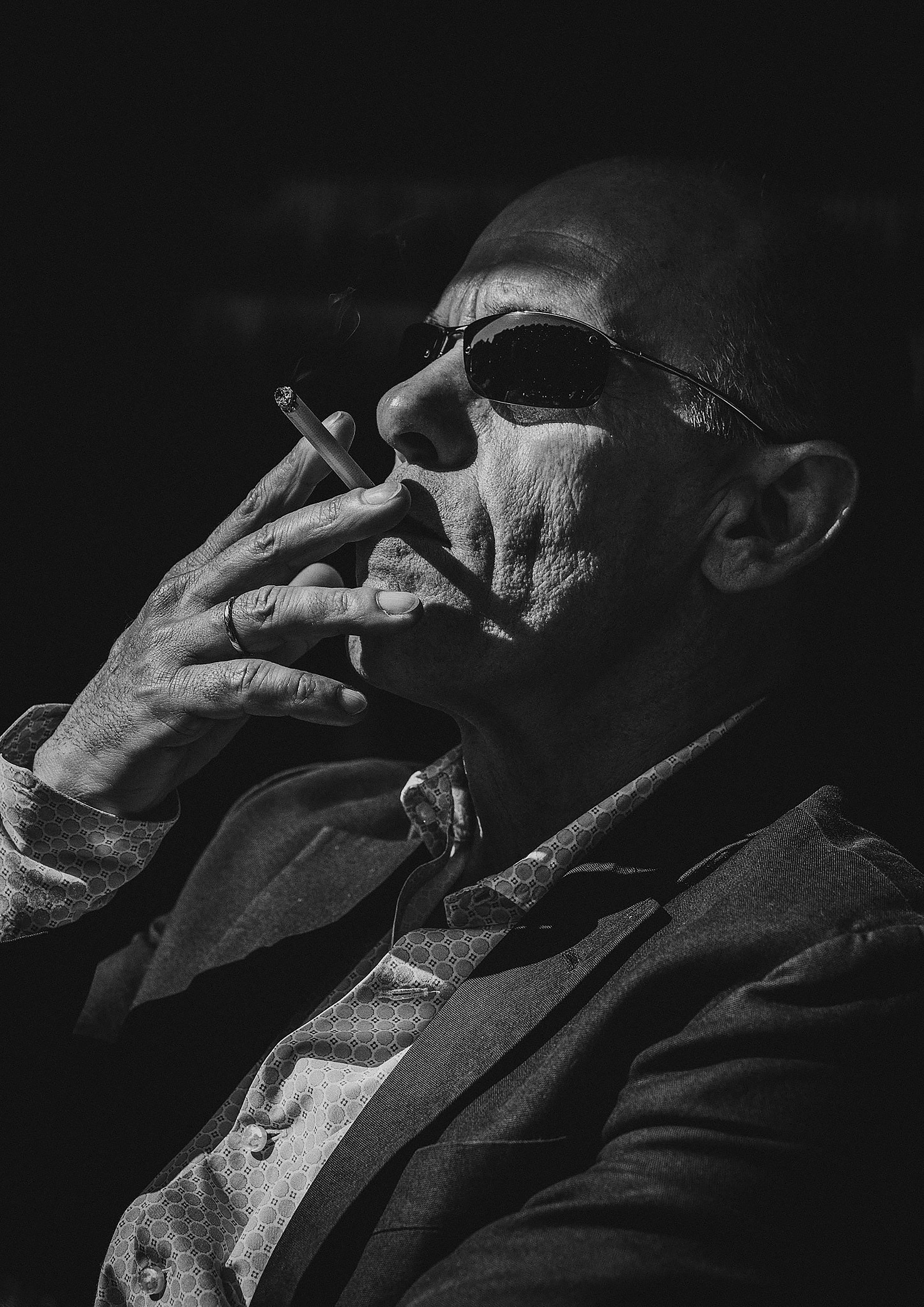 man smokes cigarette in monochrome photo