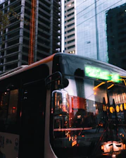 An evening view of the carlift bus parked at DIP, with city lights glowing in the background.