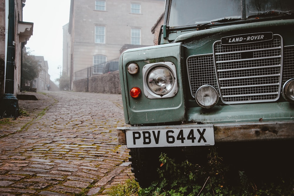 green Land-Rover vehicle park near the road