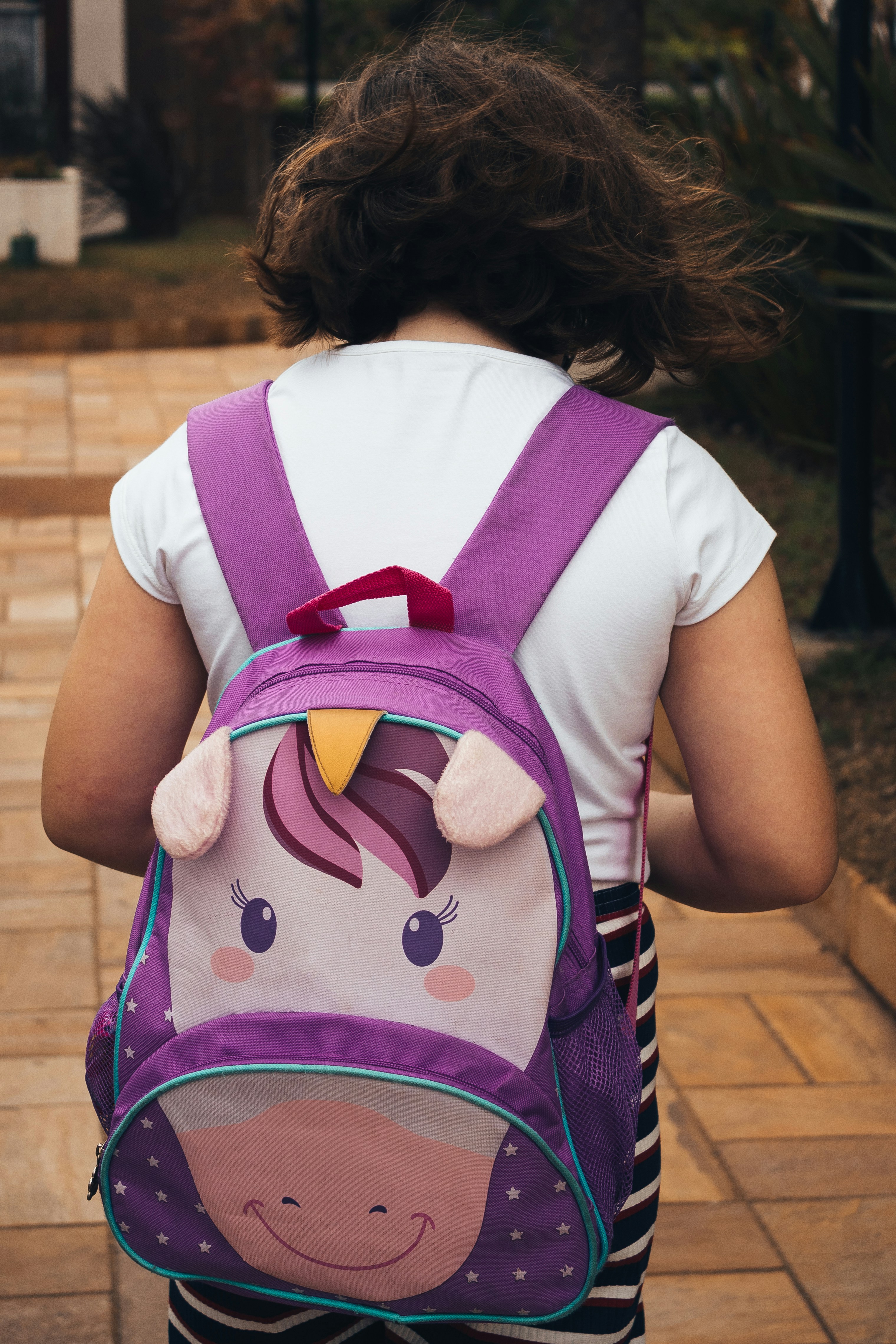 Une petite fille portant un cartable. | Photo : Unsplash