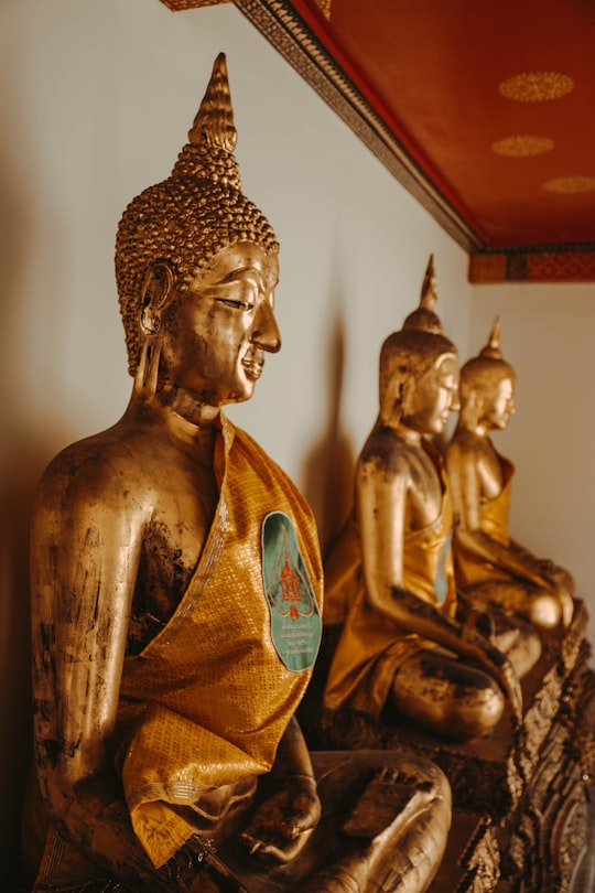 three gold buddha figurines in Saranrom Park Thailand