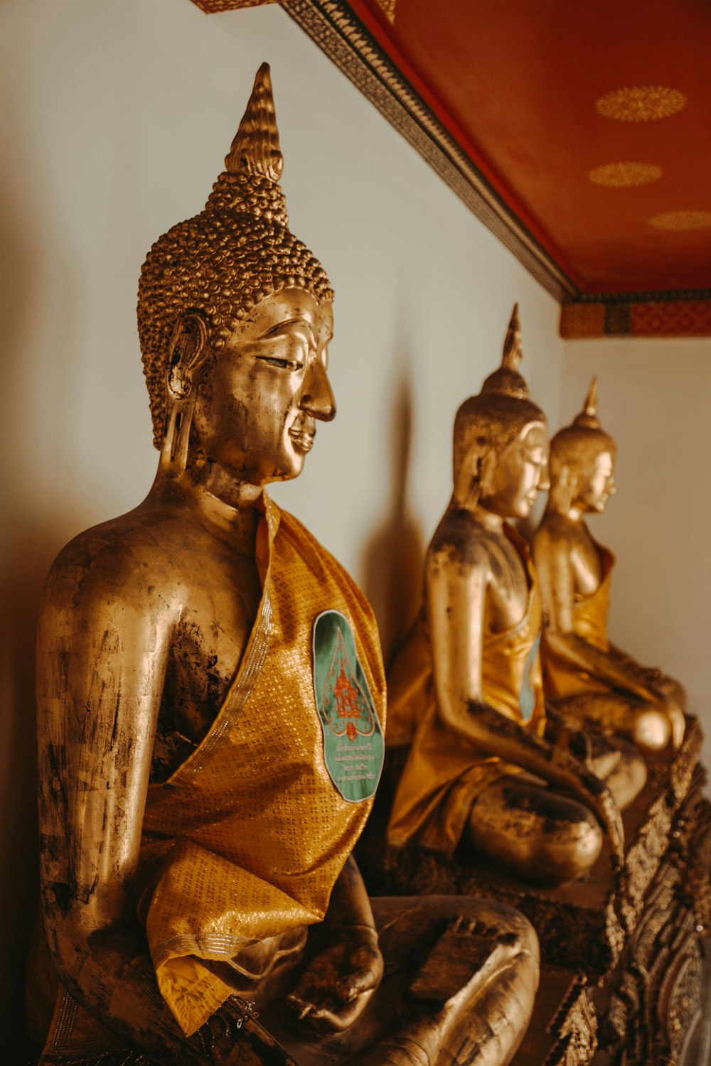 three gold buddha figurines