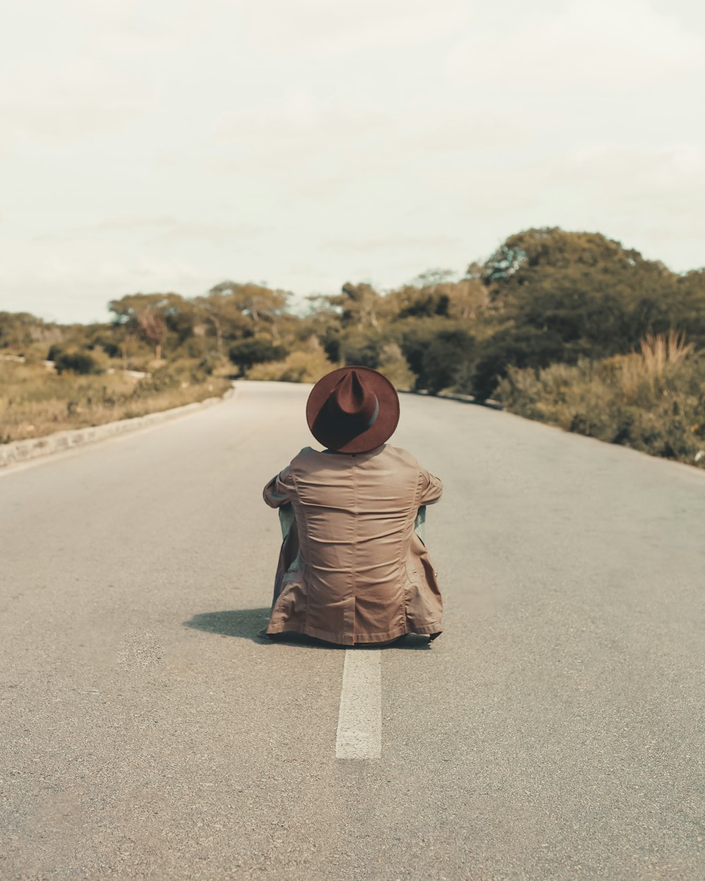 man sitting on empty road