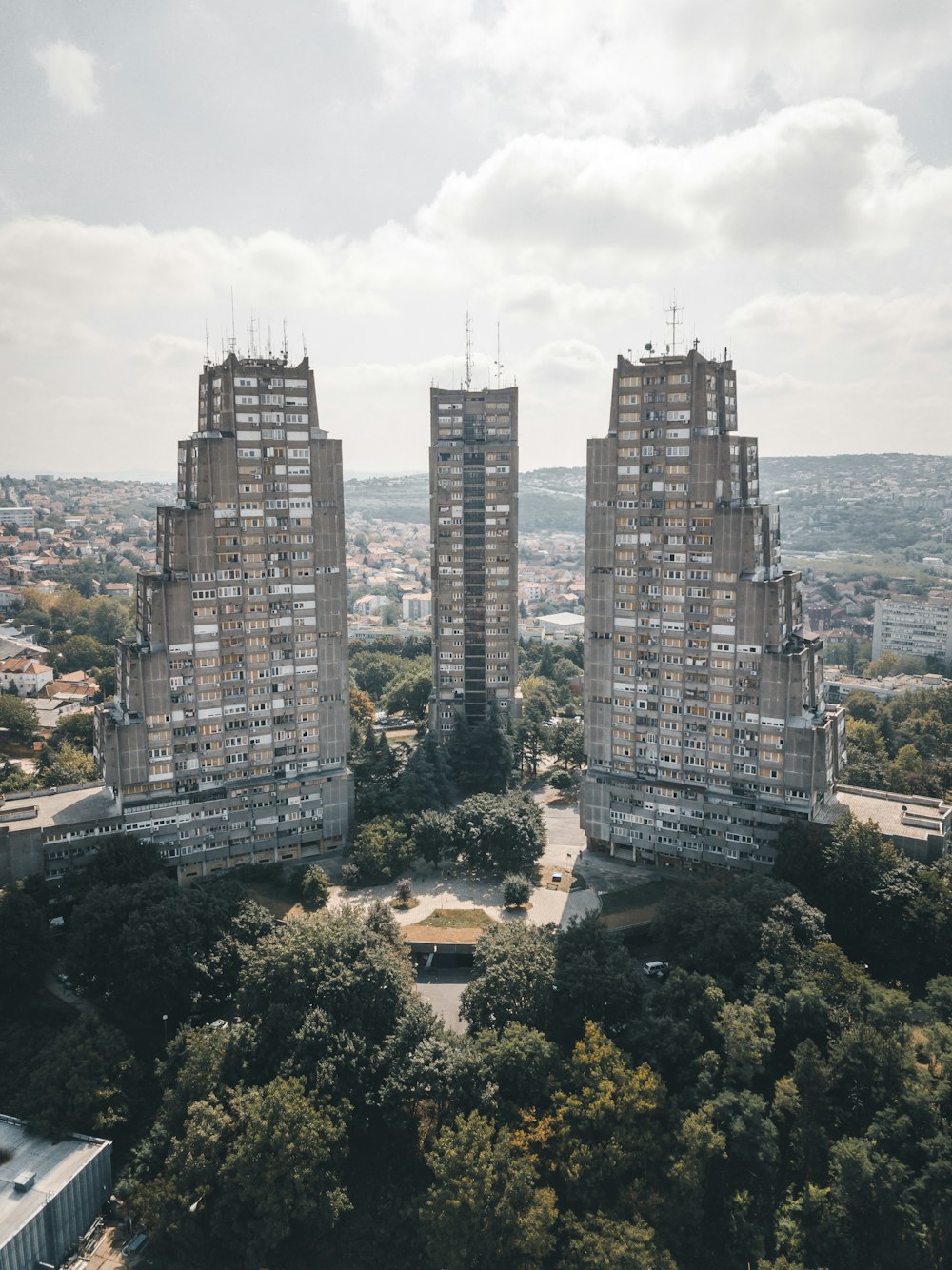 high-rise buildings and trees under cloudy sky