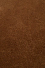 Detailed shot of premium natural leather surface with fine grain and stitching.